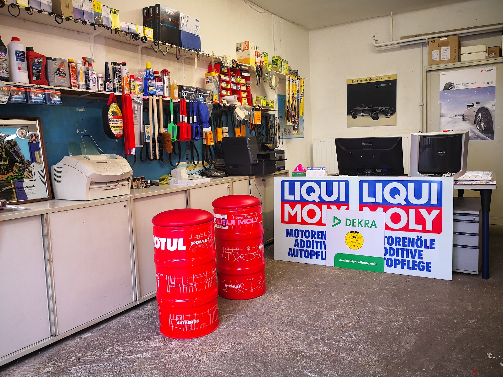 Annahmebereich mit Liqui-Moly-Aufstellern, Ölfässern und Werkzeugwand